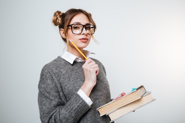 Young Woman in sweater and eyeglasses holding books