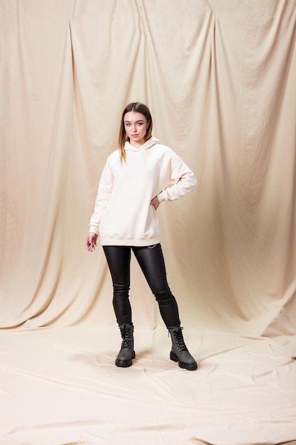 Young woman in a sweater and leather leggings. Woman in boots with natural leather on low soles