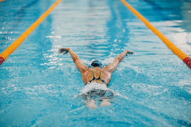 Foto il nuotatore della giovane donna nuota nella piscina