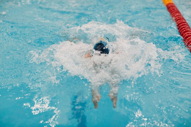 Young woman swimmer swims in swimming pool