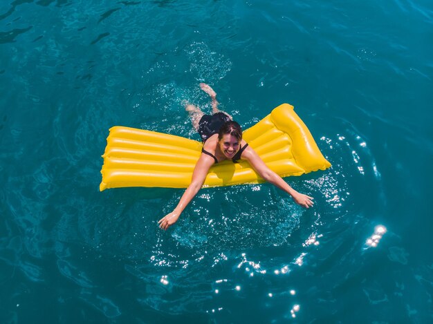 写真 青い紺碧の水で泳ぐ若い女性夏休み