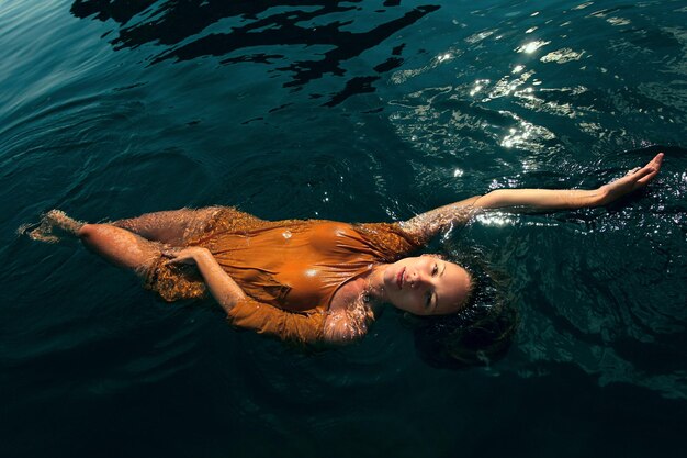 Фото Молодая женщина плавает в воде.
