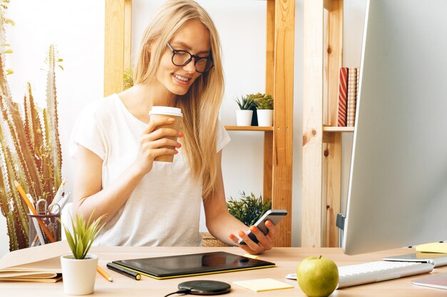 若い女性と自宅のオフィスで働くタブレット。