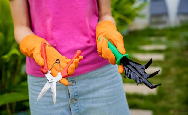 Foto una giovane donna si prende cura del giardino e lega le piante