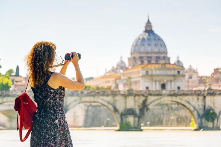 Photo young woman takes a picture of cathedral of st peter in rome