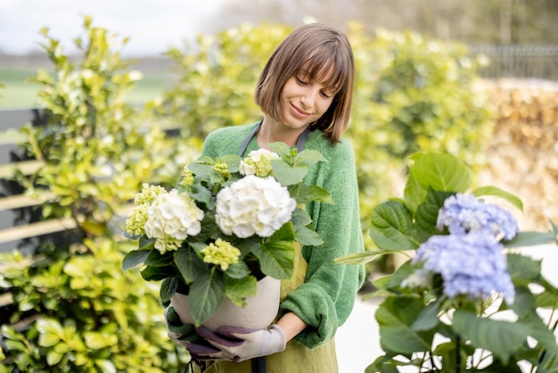 庭の花の世話をする若い女性