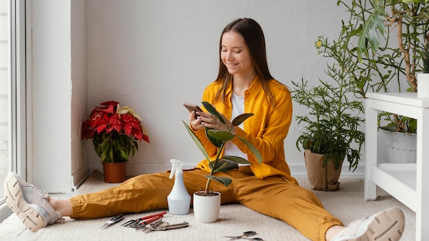 Young woman taking care of her plants indoors