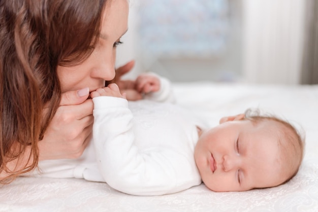 寝室で眠っている赤ん坊の娘の世話をしている若い女性