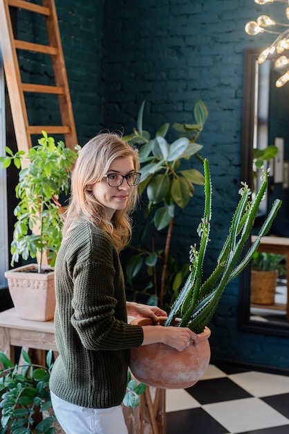 家で植物の世話をしている若い女性