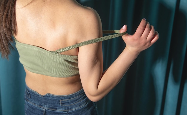 Young woman taking off a top in the home