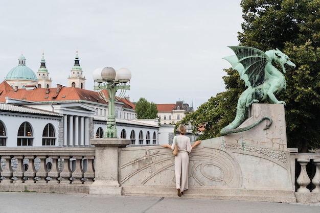 リュブリアナの有名なドラゴンブリッジの前で写真を撮っている若い女性 旅行 スロベニアを探索する ヨーロッパ