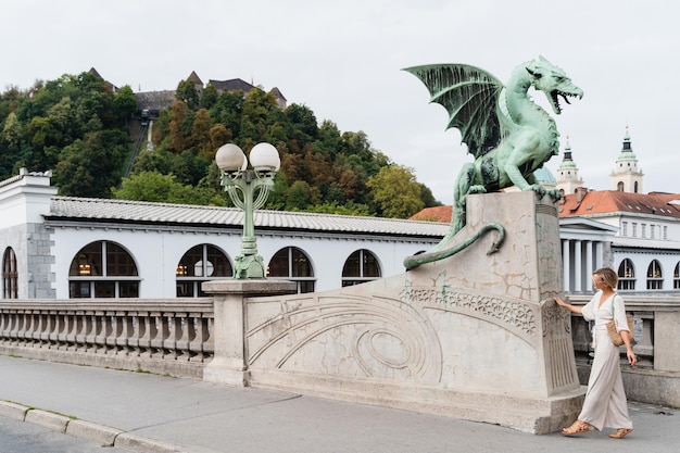 Young woman taking photo in front famous Dragon bridge in Ljubljana Travel Explore Slovenia Europe