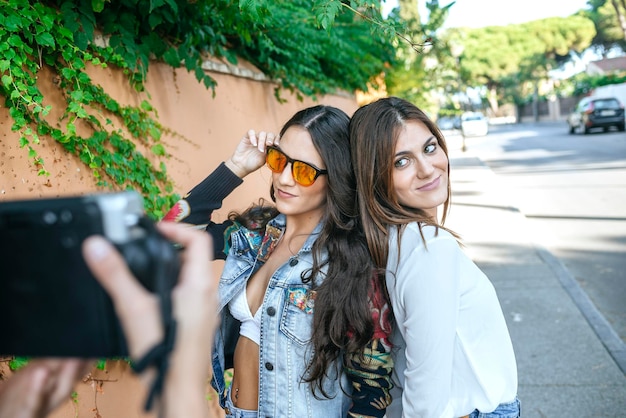 Young woman taking picture of her friends with camera