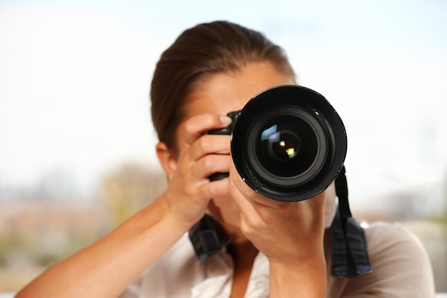 A young woman taking pictures over white background