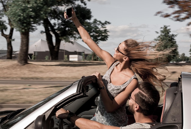 Young woman taking a selfie in the car