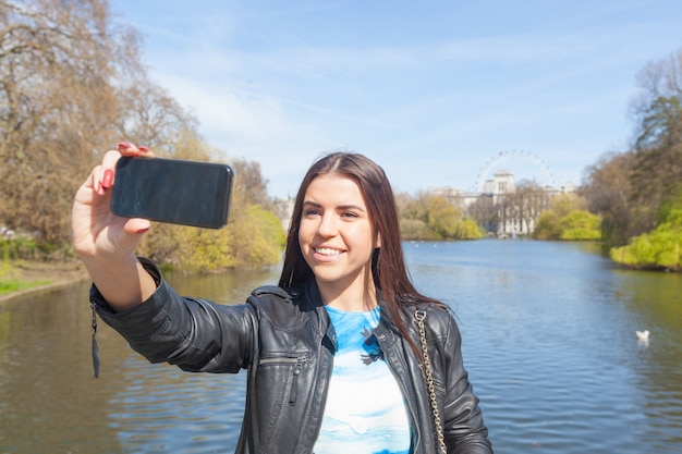 ロンドンの公園で、selfieを取っている若い女性