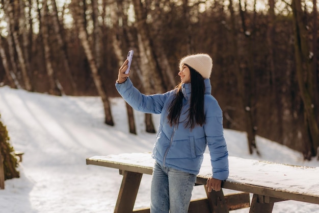 Young woman taking a selfie in winter holiday in park