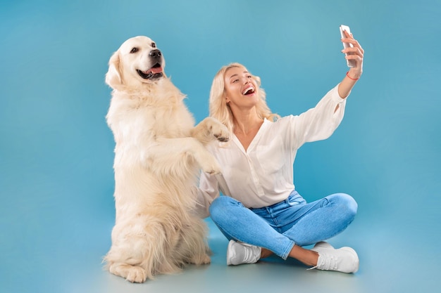 Young woman taking selfie with her dog