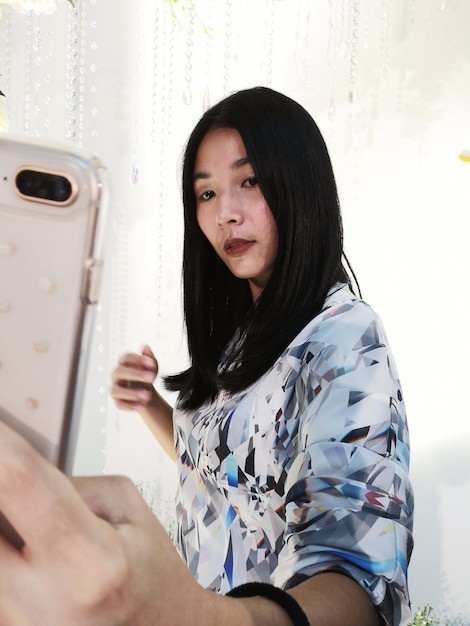 Photo young woman taking selfie with smart phone at home