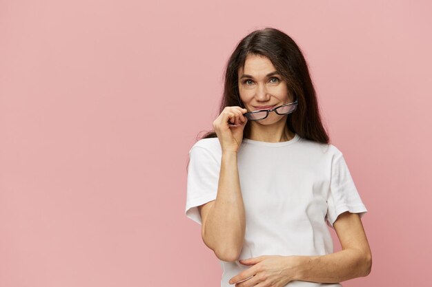 Young woman talking on mobile phone against pink background