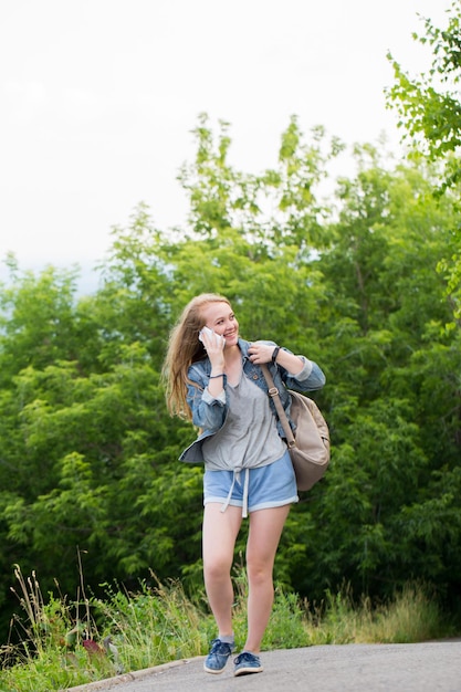 自然の中で携帯電話で話している若い女性