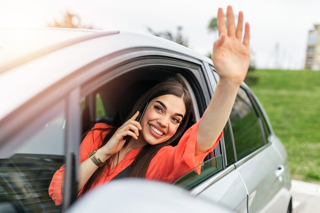 車の中で電話で話していると手を振っている若い女性。