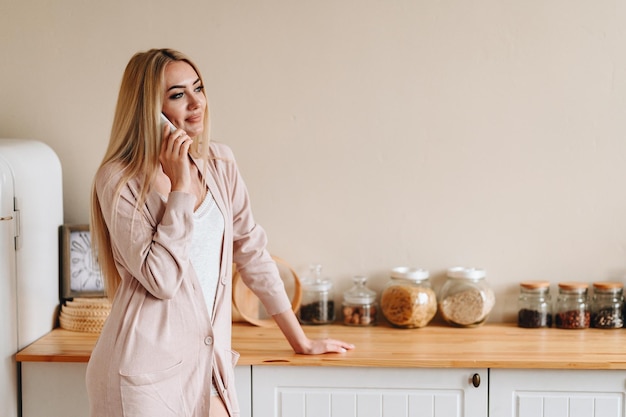 Young Woman Talking On The Phone The girl is in the kitchen Cozy kitchen interior Lifestyle