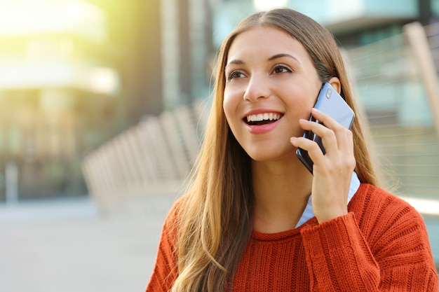 Young woman talking on the phone and looks straight ahead