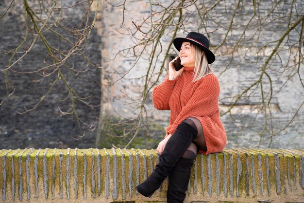 Young woman talking to the phone with friends across Europe with roaming