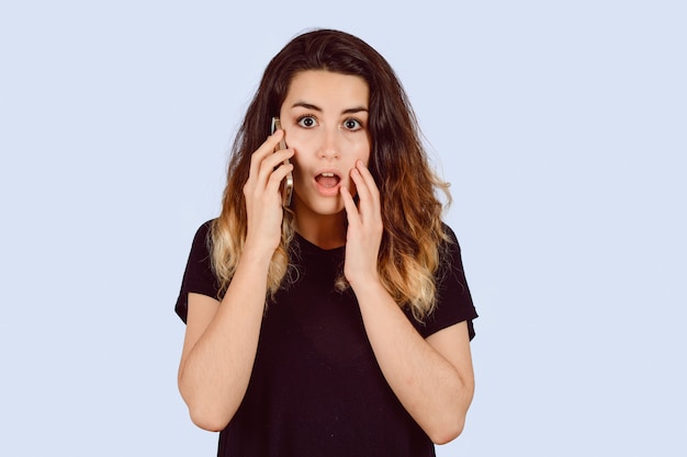 Young woman talking on phone with surprised look