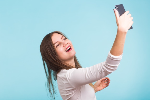 Young woman talking with friend through a video call on a smartphone. Beautiful girl having a video