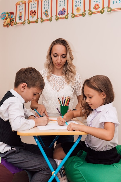 Young woman teaches children to draw