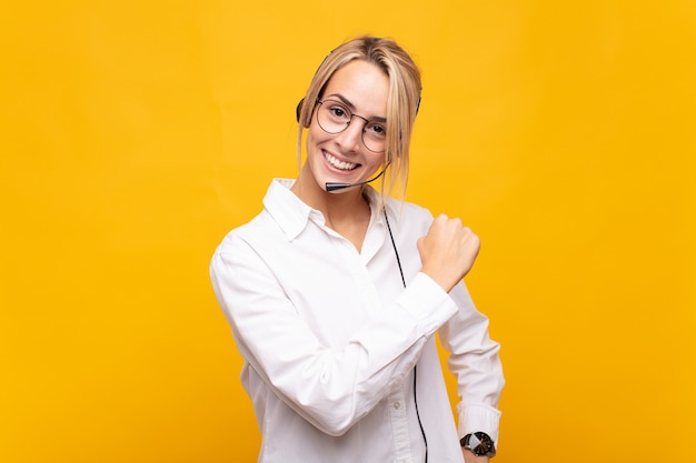 Young woman telemarketer feeling happy, positive and successful, motivated when facing a challenge or celebrating good results