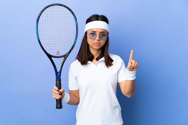 Теннисистка молодой женщины над подсчитывать одно с серьезным выражением