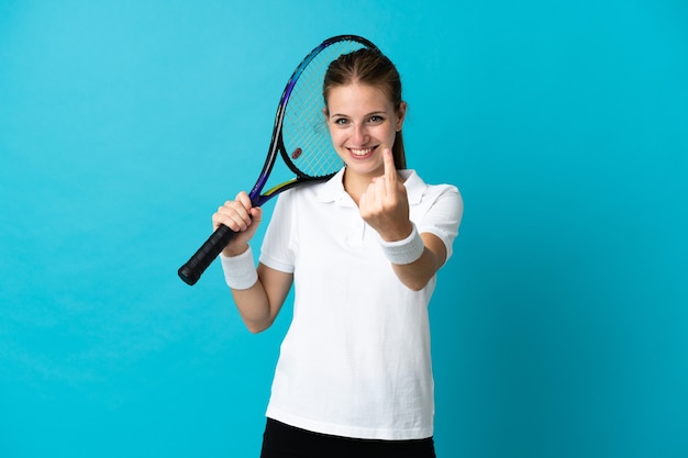 Молодая женщина-теннисистка изолирована на синем фоне, делая приближающийся жест