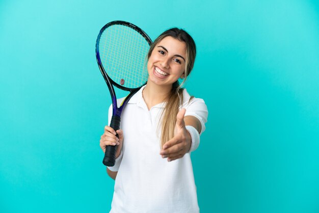 Giocatore di tennis della giovane donna isolato su priorità bassa blu che agitano le mani per la chiusura di un buon affare