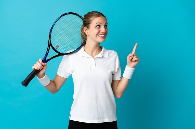 Young woman tennis player isolated on blue pointing up a great idea