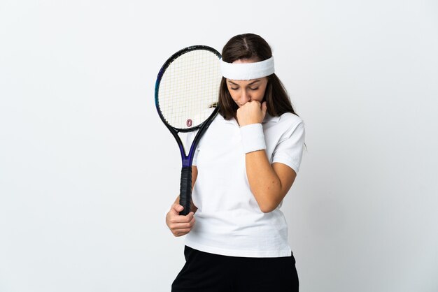 Young woman tennis player over isolated white wall having doubts