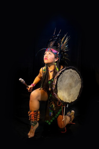 若い女性テオティワカナ、Xicalanca-黒の背景のトルテック、羽とドラムのトラップで伝統的なドレスダンス