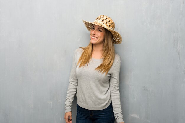 Photo young woman on textured wall with hat