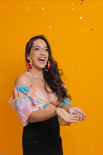 Photo young woman throwing confetti at brazilian carnival