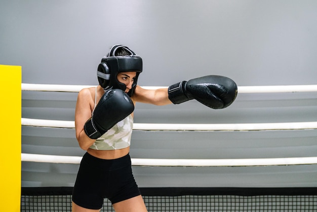 Young woman throwing a punch forward in a boxing ring