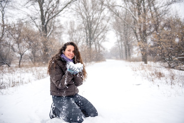 Foto giovane donna che getta neve, felice e divertente