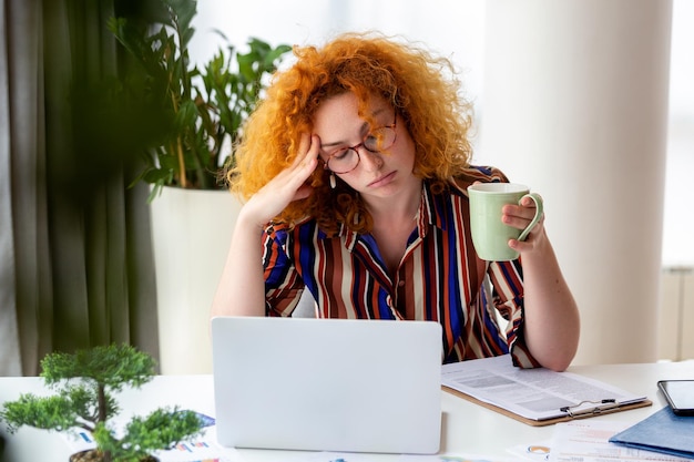 Young woman tired exhausted from working studying hard Bored and frustrated Head resting on hand Bright space big windows At home concept Stress concept