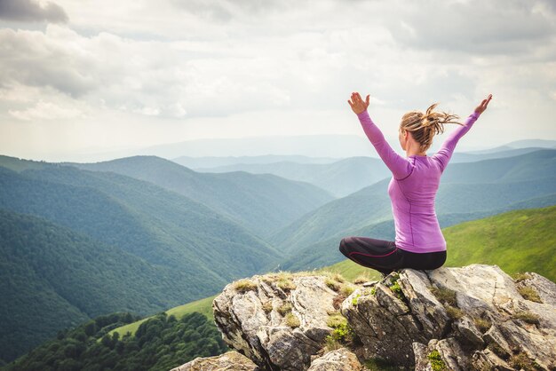 Foto giovane donna in cima alla montagna