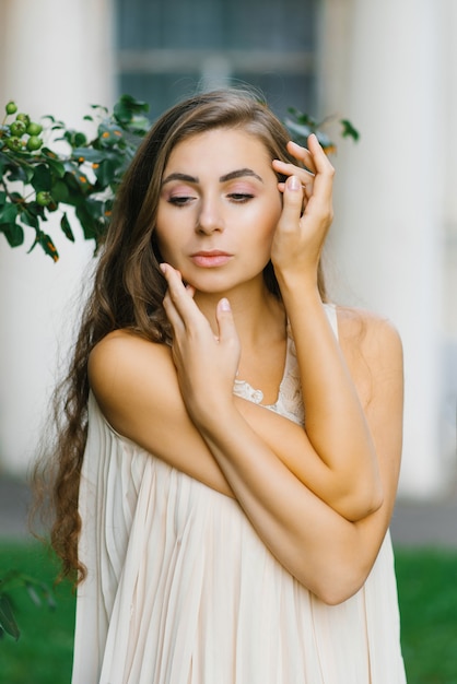 A young woman touches her face with her hands. The concept of caring and self-love