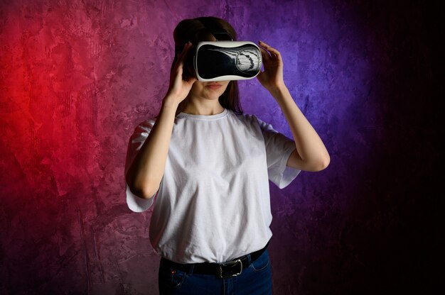 Young woman touching the air during the VR experience. Blue and red wall