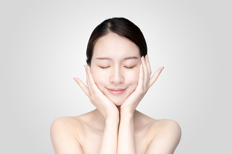 Photo 편안한 표정으로 얼굴을 만지고 젊은 여자