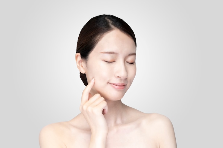 Photo 편안한 표정으로 얼굴을 만지고 젊은 여자