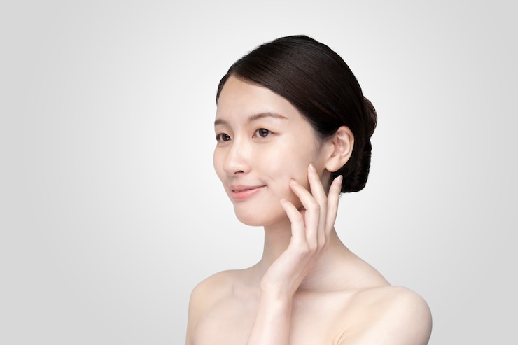 Photo 편안한 표정으로 얼굴을 만지고 젊은 여자